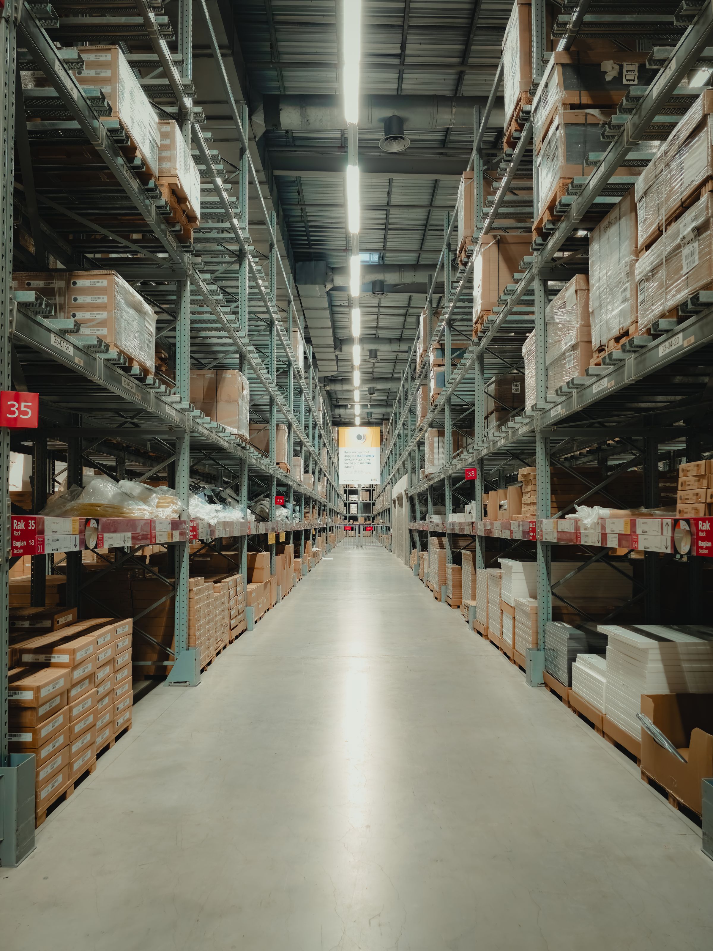 Store aisle with shelves and pallets of stocked products